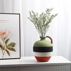 Close-up of Nordic ceramic vase with colorful hand-painted horizontal stripes