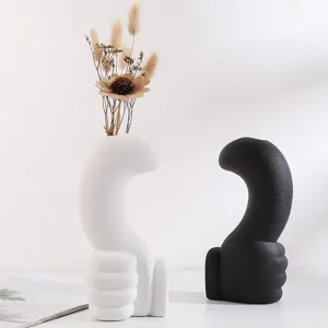 Detailed view of modern matte black and white thumb-shaped ceramic vases for home decor.