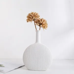 Moderne minimalistische witte keramische vaas met geribbelde textuur en droogbloemen
