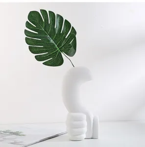 Modern minimalist white ceramic hand-shaped vase for home decor with monstera leaf detail