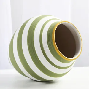 Macro view of green and white hand-painted stripes on a Nordic ceramic vase detail