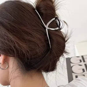 Primo piano dettagliato di un elegante mollettone per capelli in metallo argentato sicuro.