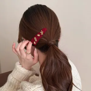 Rode fluwelen haarspeld met gouden metalen bedels, elegante haaraccessoire voor dagelijks gebruik.