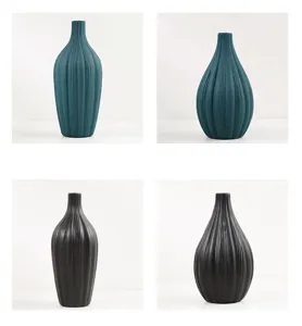 Cuatro jarrones de cerámica minimalistas en negro y azul con elegantes detalles de vetas