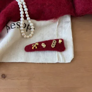 Rode fluwelen haarspeld met gouden metalen bedels, perfect voor de feestdagen in de nieuwe stijl.