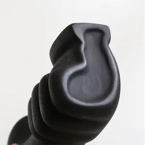 Macro detail showing the elegant matte grainy texture of the black irregular ceramic vase.