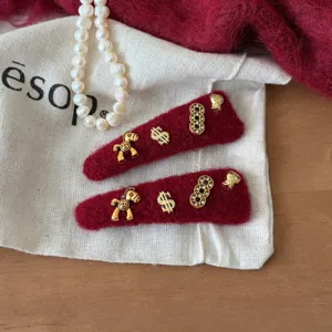 Rode fluwelen haarspelden met gouden metalen bedels, perfecte feestelijke haaraccessoires.