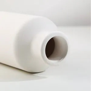 Détail macro de l'ouverture émaillée lisse d'un vase en céramique blanche minimaliste
