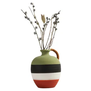 Hand-painted striped ceramic vase with rustic handle and decorative dried branches