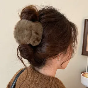 Gros plan détaillé de la pince à cheveux en peluche marron, idéale pour les coiffures élégantes.
