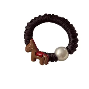Chique geplooide haarelastiek met bruin paardenbedeltje en parel voor stijlvolle paardenstaart.