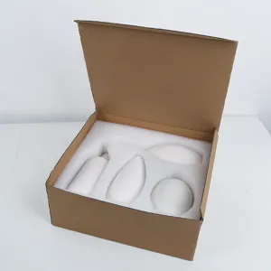 Ensemble de quatre petits vases minimalistes en céramique blanche dans une boîte protectrice.