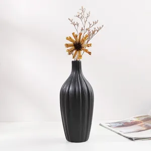 Jarrón minimalista de cerámica negro mate con textura acanalada y flores secas decorativas