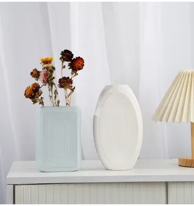 Modern matte ceramic vases with geometric textures in a minimalist living room setup