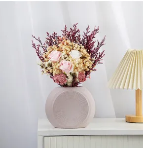 Detailed view of matte ceramic vase featuring elegant pink roses and delicate baby's breath