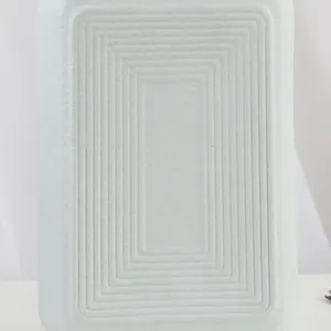 Macro view of a cream matte ceramic vase featuring concentric rectangle grooved texture details