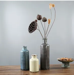 Dettaglio di tre vasi rustici in ceramica in grigio, blu e crema per l'arredamento della casa.
