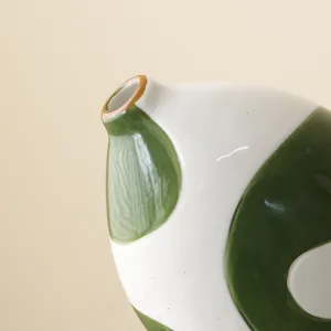 Detailed macro shot of a handmade Wabi-sabi ceramic vase with green painted dots