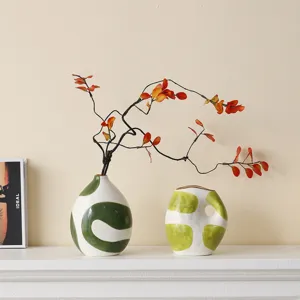 Detail of hand-painted Wabi-sabi ceramic vases with artistic green dot patterns