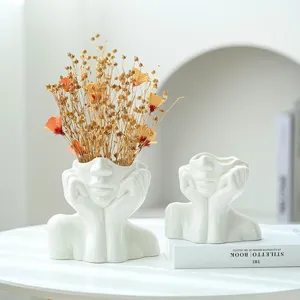 Vase moderne en céramique blanche brillante en forme de visage pour déco épurée.