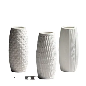 Set of three modern white ceramic vases with textured patterns for table decor