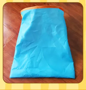 Detail of a blue crinkle cat tunnel bag toy with orange rim resting on a wooden floor