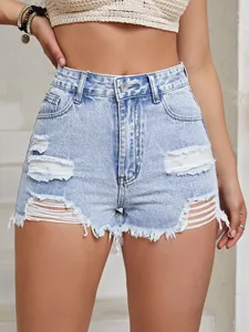 Macro close-up view of light wash distressed denim shorts with frayed hems and ripped detailing
