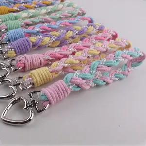 Nahaufnahme von bunten handgefertigten geflochtenen Handy-Lanyards mit Herz-Schlüsselanhängern.