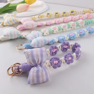 Close-up detail of handmade crochet flower phone strap featuring a cute plaid bow accent.