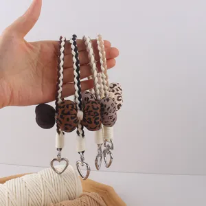 Cute leopard print braided phone lanyard keychain detail, stylish wrist strap charm.
