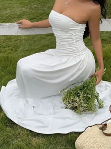 Detailed macro shot of white strapless ruffled waist maxi dress for elegant resort wear