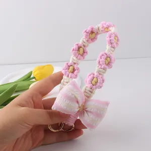 Handmade crochet flower phone charm strap with pink bow keychain accessory for cute phone case.