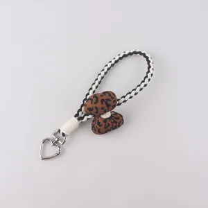 Detailed close-up of the cute leopard print pendant and black white woven rope keychain detail.