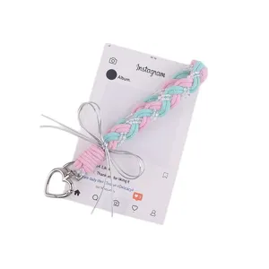 Handgemaakte gevlochten telefoonkoord en tastas met zilveren strik en pastelkleurig touw design.