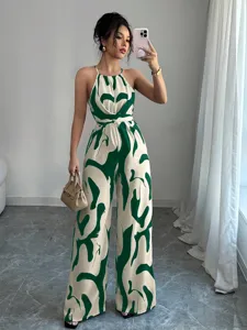 Elegant green and cream abstract printed halter neck wide-leg jumpsuit with cinched waist