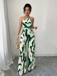 Detailed view of women's halter neck wide-leg jumpsuit with green abstract print