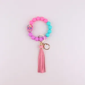 Silicone bead keychain bracelet with pink sugar skull pendant and leather tassel for daily use.