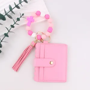 Pink leather card holder wallet with silicone cross bead wristlet keychain and tassel.