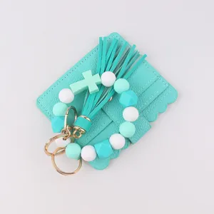 Mint green silicone beaded keychain, leather cardholder detail view, tassel and cross charm.