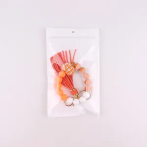 Detailed view of Halloween silicone beaded wrist keychain with orange tassel and pumpkin charm.