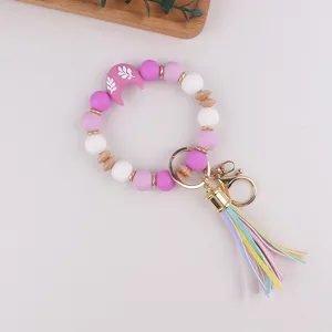 Llavero de pulsera con cuentas de silicona, colgante de luna y borla de cuero.