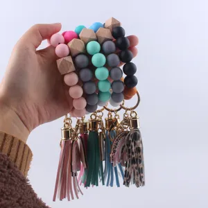 Silicone beaded keychain bracelet with wooden beads and tassels, fashionable gift for women.