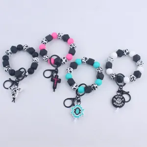 Silicone bead wristlet keychain with cute charms, stylish cow print and vibrant colors.