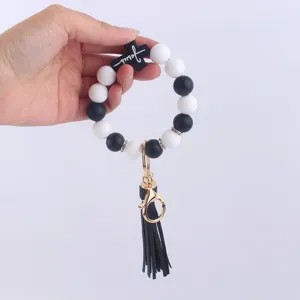 Silicone bead bracelet keychain with cross pendant and black tassel for women fashion accessory.