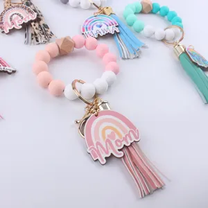 Detailed view of silicone bead wristlet keychain with leather tassel and cute rainbow charm.