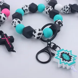 Silicone bead wristlet keychain detail, cow print charm, trendy DIY fashion accessory.