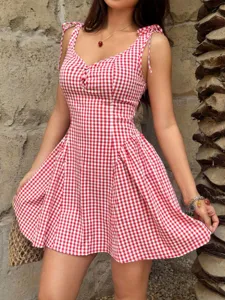 Close-up of a red and white gingham mini dress featuring sweet tie-shoulder straps