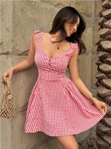 Detailed view of red and white gingham sundress with tie-shoulder straps and flared skirt