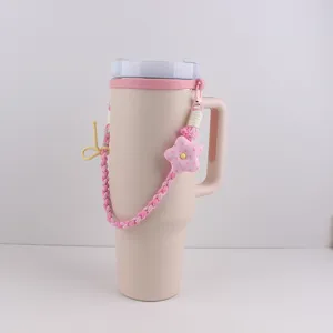 Detailansicht des rosa Bechers mit handgeflochtenem Riemen, Stern- und Schleifenanhänger.