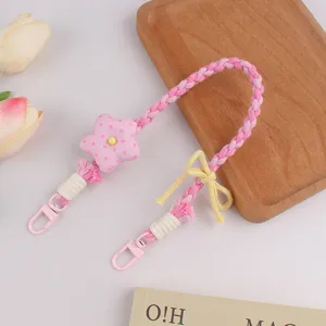Handgemachte geflochtene Handykette mit süßem rosa Stern und gelber Schleife Detail.